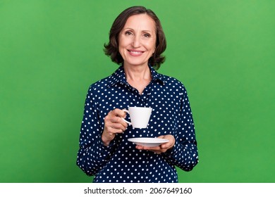 Photo Of Cute Old Lady Drink Tea Wear Dotted Blouse Isolated On Green Color Background