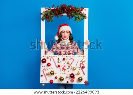 Photo of cute pretty flirty lady wear trendy sweater hold social media cadre window pouted plump lips isolated on blue color background