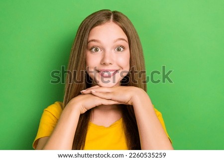 Photo of cute smiling satisfied little lady teenager schoolgirl wear orange t-shirt hands together after dentistry isolated on green color background