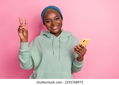 Photo of cute stylish female social media blogger showing v sign being friendly isolated on pink color background - Powered by Shutterstock