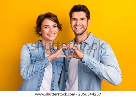 Photo of cute sweet pretty couple wear trendy denim clothes arms showing gesture make symbol heart shape isolated yellow color background