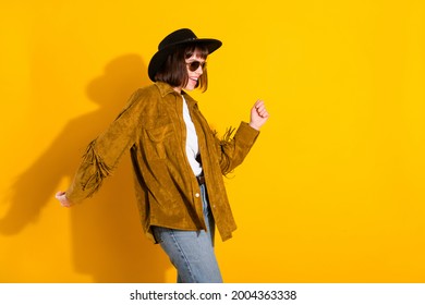 Photo of cute sweet woman dressed cowboy clothes dark spectacles cap smiling dancing empty space isolated yellow color background