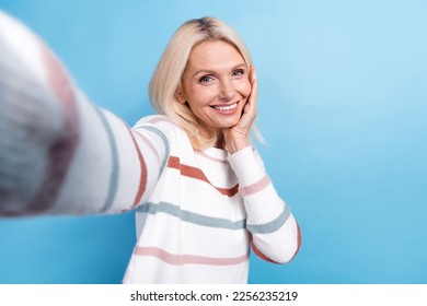 Photo of cute sweet woman dressed striped sweater recording video hand arm cheek cheekbone isolated blue color background - Shutterstock ID 2256235219