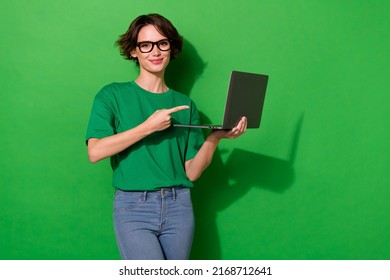 Photo Of Cute Sweet Woman Wear Casual T-shirt Arm Spectacles Pointing Modern Device Isolated Green Color Background