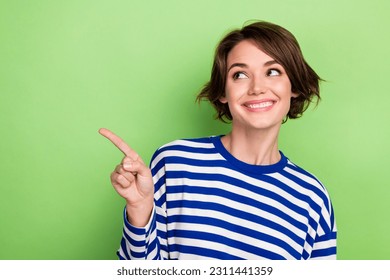 Photo of cute woman showing mockup empty space look interested wondered wear pullover isolated green color background - Powered by Shutterstock