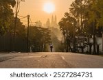 Photo of a cyclist from behind with Kuala Lumpur skyline at the background during sunrise