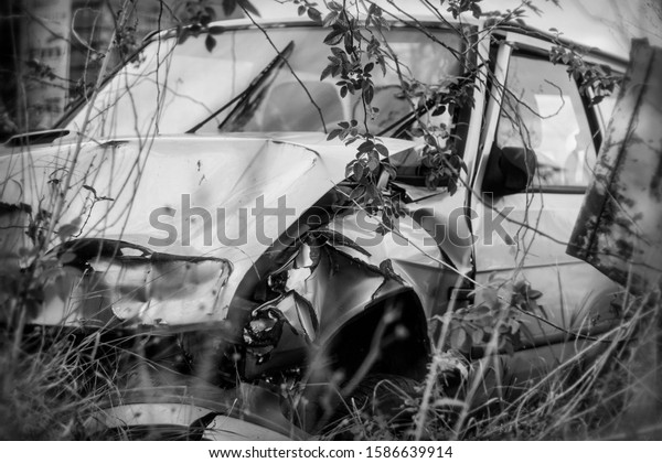 Photo of damaged\
and rusty car after\
crash.