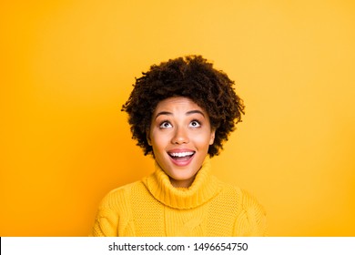 Photo of dark skin lady looking up empty space at unbelievable sale season prices wear warm knitted sweater isolated yellow color background