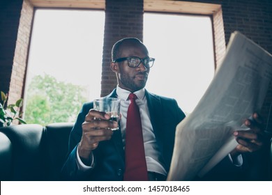 Photo Of Dark Skin Macho Guy Sitting Office Sofa Drinking Alcohol Beverage Reading Fresh Press Wear Elegant Costume