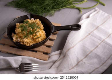 photo Delicious Scrambled Eggs with Fresh Dill Garnish Served in a Cast Iron Skillet on Rustic Table Setting for Breakfast or Brunch Gourmet Experience - Powered by Shutterstock