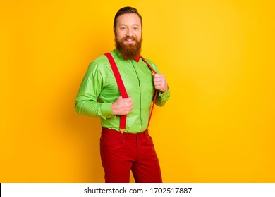 Photo Of Delighted Red Head Guy Toothy Smiling Elegant Funky Party Look Hold Hands Suspenders Wear Bright Green Shirt Red Bow Tie Pants Isolated Yellow Color Background