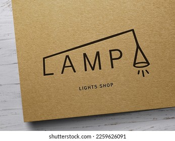 The photo depicts a sleek business card for a lights shop.The logo is a stylized representation of a lightbulb. Beneath the logo, the shop's name is printed in a sleek sans-serif font, also in.