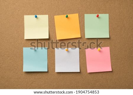 Photo of different colorful memo papers attached with pins to the wooden board