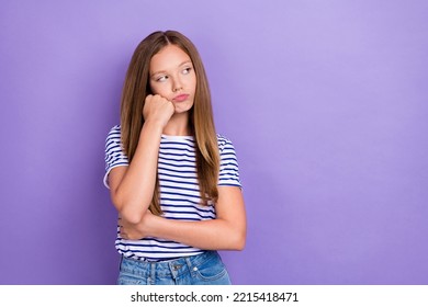 Photo Of Displeased Upset Girl Straight Hairdo Wear Striped T-shirt Look Empty Space Hand On Cheekbone Isolated On Purple Color Background