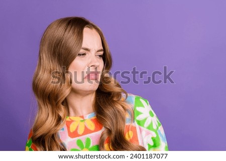 Photo of dissatisfied woman with wavy hair wear print t-shirt look at disgusting thing in empty space isolated on purple color background
