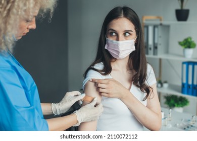 Photo With A Doctor Applying A Bandaid To Her Patients Arm. Doctor Apply Vaccine Patient. Doctor Hand. Virus Protection. Covid-19 Flu Protection. Covid-19