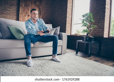 Photo Of Domestic Handsome Guy Relaxing Stay Home Quarantine Time Playing Video Games Playstation Football Final Match Sit Cozy Sofa Modern Interior Living Room Indoors