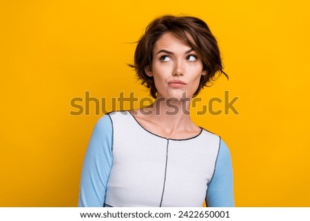 Photo of doubtful unsure woman wear top looking empty space isolated yellow color background