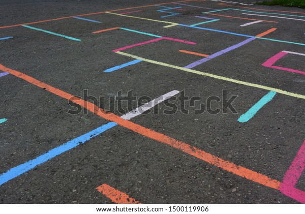 Photo with drawings of chalk on the pavement.\
Multi-colored maze