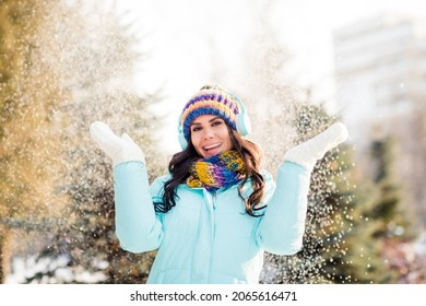Photo of dreamy dancer lady listen music throw snow wear earphones hat scarf gloves coat in winter park outside