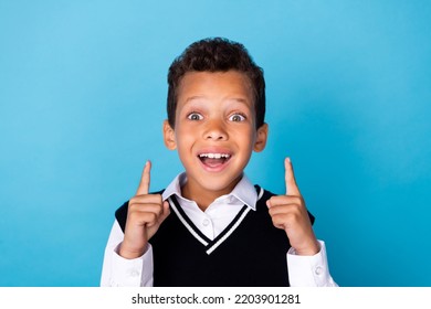 Photo Of Dreamy Excited Little Guy Dressed Black Vest Pointing Up Two Fingers Empty Space Isolated Blue Color Background