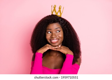 Photo of dreamy girl palms chin look empty space wear crown top uncovered shoulders isolated pink color background