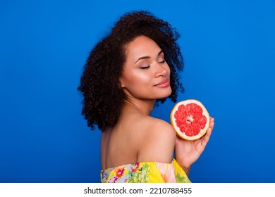 Photo Of Dreamy Gorgeous Lady Wear Yellow Top Smiling Holding Ripe Orange Fruit Isolated Blue Color Background