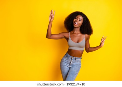 Photo of dreamy inspired lady look empty space have fun wear cropped singlet isolated yellow color background