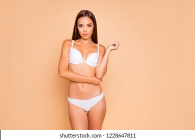 Photo of dreamy leisure lifestyle cute nice sweet lady in her white underwear she look at camera hold hands close to body stands isolated on pastel beige background