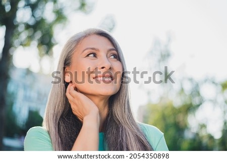 Photo of dreamy thoughtful creative pensioner lady look clear sky wear turquoise t-shirt urban city outside