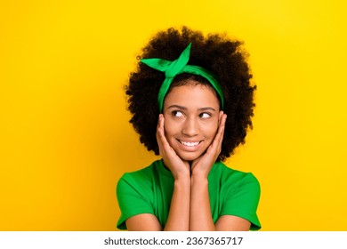 Photo of dreamy thoughtful lady wear green t-shirt hairband arms cheeks looking empty space isolated yellow color background - Shutterstock ID 2367365717