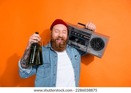 Photo of drunk excited guy dressed denim jacket holding boom box beer bottles isolated orange color background