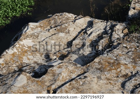 Photo of dry yellow soil, very big rocks on country road on summer day. rock masses eroded by rain. brown soil that has been dry. amazing natural nature photo. soil background. green grasses and lawns
