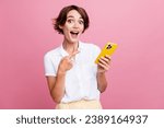 Photo of ecstatic impressed girl with bob hairdo dressed white shirt directing at smartphone staring isolated on pink color background