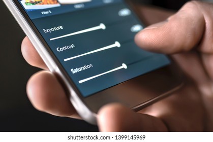 Photo edit with mobile phone and smart app. Man adjusting sliders. Image editing, manipulation, improvement or enhancement with smartphone. Adding filter to photograph in social media application. - Shutterstock ID 1399145969
