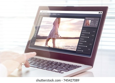 Photo Editing. Professional Editor Retouching An Image With Laptop And Imaginary Computer Software. All Graphics Are Made Up.