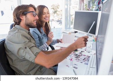 Photo editors working together at desk and smiling in bright modern office - Powered by Shutterstock