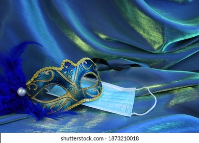 Photo of elegant and delicate Venetian mask over blue silk background. Coronavirus prevention concept