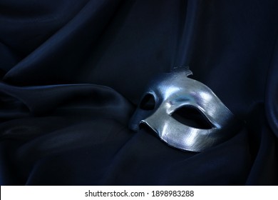 Photo of elegant and delicate Venetian mask over black silk background
