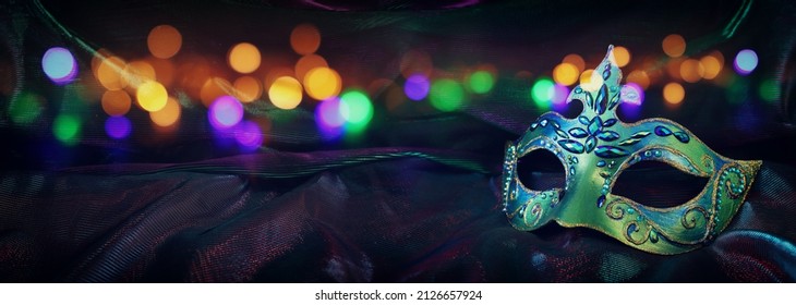 Photo of elegant and delicate Venetian mask over dark background. banner