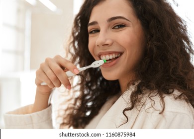 Photo of emotional beautiful young cute woman in bathroom brushing cleaning her teeth. - Powered by Shutterstock