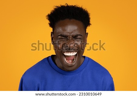 Photo of emotional screaming young black man with closed eyes standing isolated over colorful yellow studio background, closeup shot. Human emotions, facial expression concept