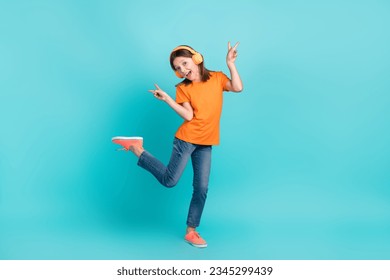 Photo of energetic crazy cute girl wear stylish orange clothes hand demonstrate v-sign good mood isolated on cyan color background