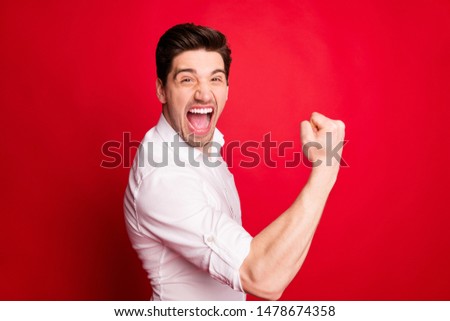 Photo of enjoying rejoicing man wearing formal clothing showing his happiness and satisfaction while isolated with red background