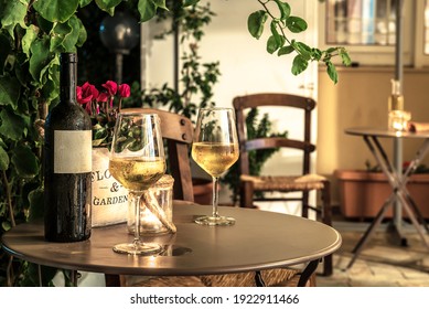 Photo With Evening Light. Misted  Glasses With White Wine And Bottle On The Table. Outside Bar Terrace. Cafe Concept. Selective Focus. 