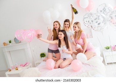 Photo of excited adorable young ladies nightwear recording self video drinking wine indoors house room - Powered by Shutterstock