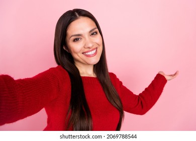 Photo of excited brunette lady do selfie hold empty space wear red pullover isolated on pink color background