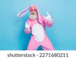 Photo of excited cool retired guy wear pink hare sleepwear heart glasses showing hard rock signs isolated blue color background
