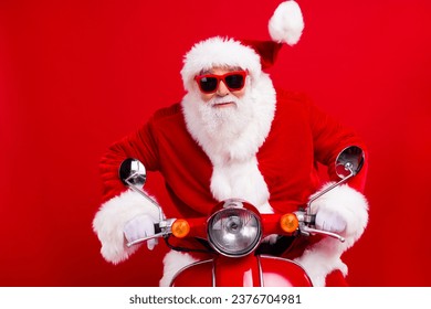 Photo of excited crazy elderly santa drive bike fast north pole christmas fairy isolated on vivid red color background - Powered by Shutterstock