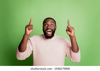 Photo of excited crazy man indicate forefingers up empty space open mouth wear white shirt over green background - Powered by Shutterstock